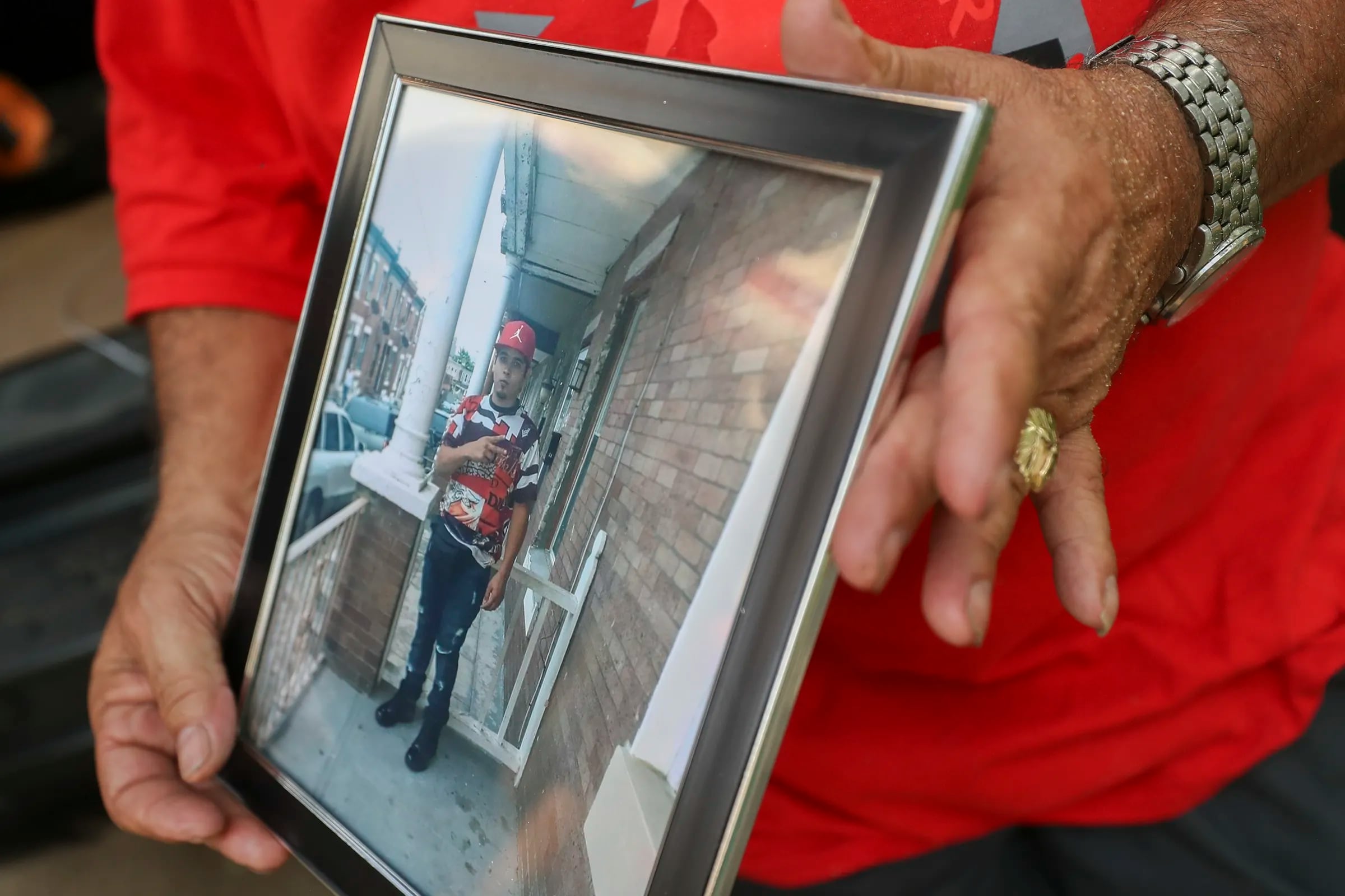 Nelson Garcia, 65, grandfather of Eddie Irizarry, holds up a photo of Irizarry while building a small altar for him outside of the family’s home in the West Kensington section of Philadelphia on Aug. 16, 2023. 
