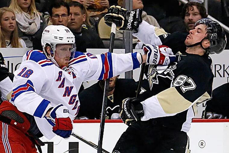 The Rangers' Marc Staal stiff arms the Penguins' Sidney Crosby off the puck. (Gene J. Puskar/AP)