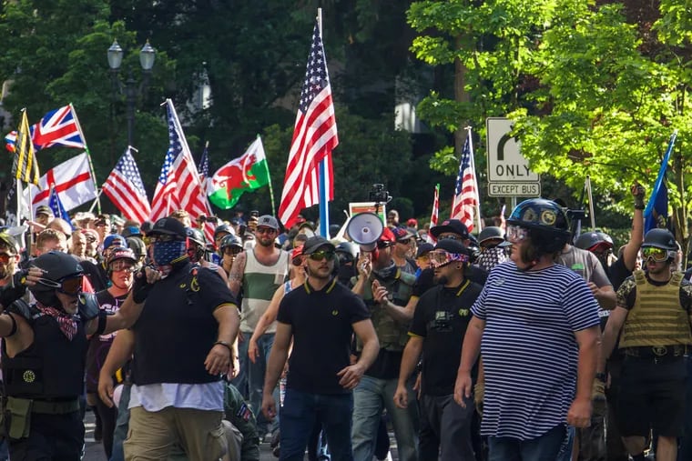 The first line of Proud Boys and members of the group Patriot Prayer walk toward antifa's "black bloc," who wear black clothing to conceal their identities.