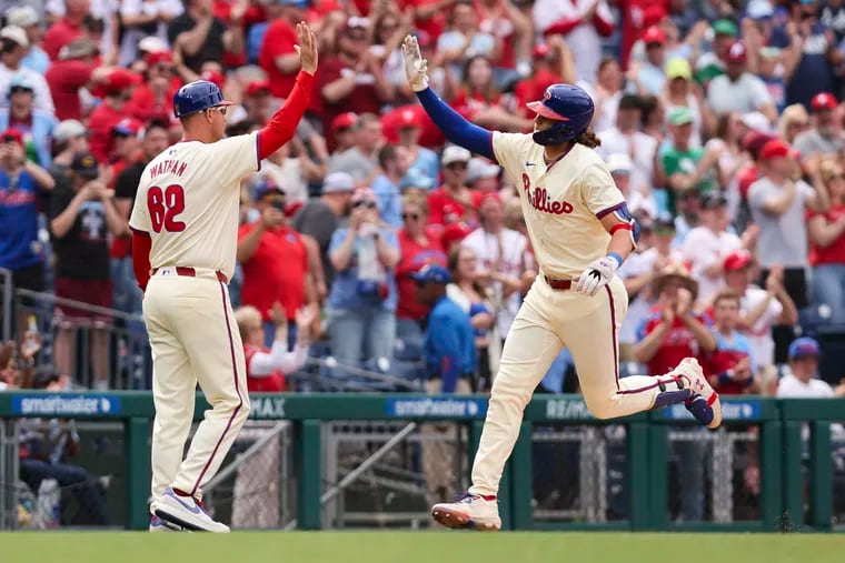 The Phillies' Alec Bohm celebrates with third-base coach Dusty Wathan after he hit a three-run home run during the eighth inning against the Nationals.