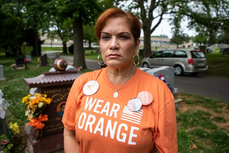 Lisa Espinosa, of Huntington Valley, Pa., poses by her son, Raymond J. Pantoja, at the Greenmount Cemetery Friday afternoon June 7, 2019. Espinosa fought six and a half months for justice for her sons death.