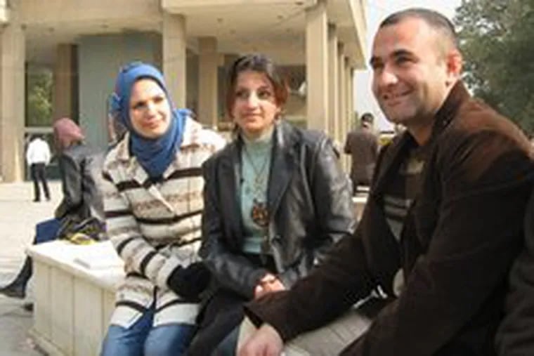 In the Baghdad University courtyard , Duaa Ali (left) and Donia al-Shakly visit with a former student, Luay Ahmed. The diverse student body, from all over the city and the country, offers a glimpse into the national mood during a lull in war tensions.