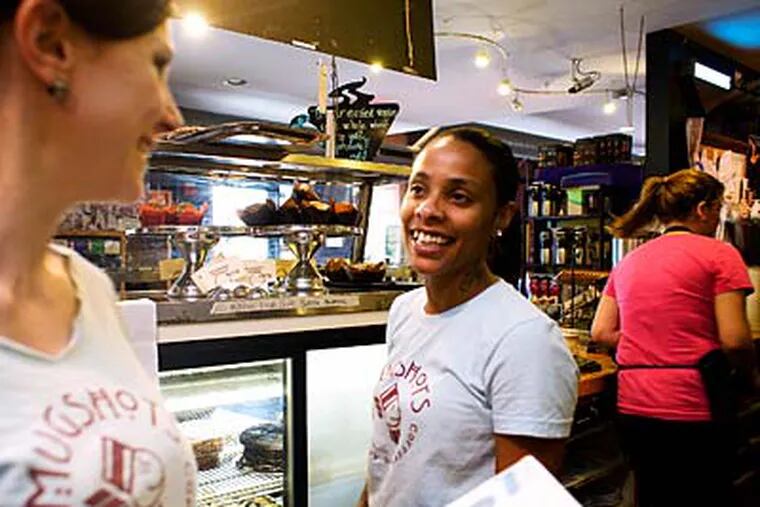 At Mugshots coffee shop in Brewerytown, worker Rosangela DelCampo (right) chats with owner Angela Vendetti. She wants to hire 10 more whose wages are paid by the government. (ED HILLE / Staff Photographer)