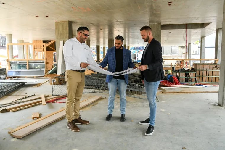 Restaurateur Justin Veasey (left) with developer Michael Stamm (right) and project manager Abel Santos Jr. in the SIN Philadelphia space at 1102 Germantown Ave.