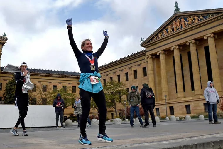 On the day before the 40th anniversary of the classic movie, Helene Fortier (right), 52, of Ottawa, Canada celebrates Rocky-style on the top of the Philadelphia Museum of Art steps as David Hauser (left), 22, of Manhattan, N.Y. photographs her after they completed the Philadelphia Marathon.