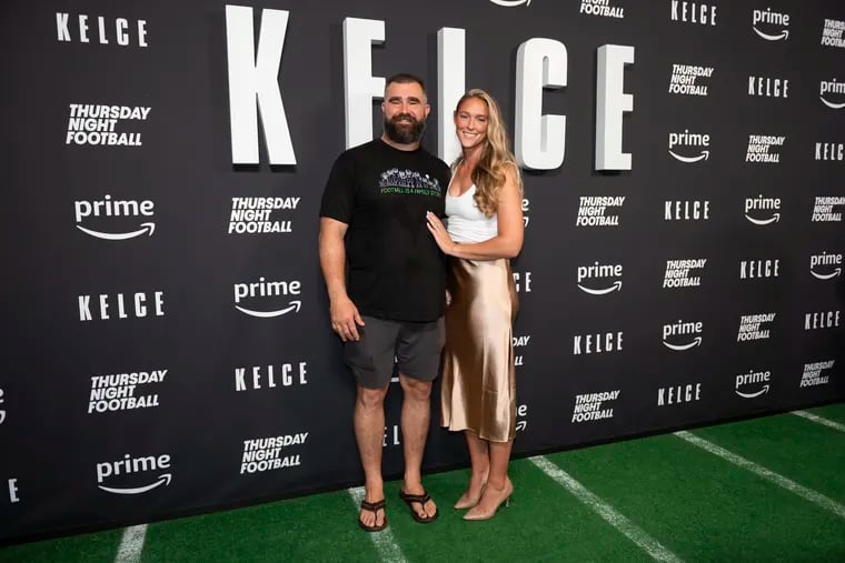 Jason Kelce (left) and his wife Kylie Kelce (right) pose for a photo together at the premier of Jason Kelce’s documentary at Suzanne Roberts Theater in Philadelphia on Friday, Sept. 9, 2023. Kylie signed a Princess Diana-Eagles varsity jacket, which garnered a $100,000 bid for a charity auction in support of the Eagles' Autism Foundation