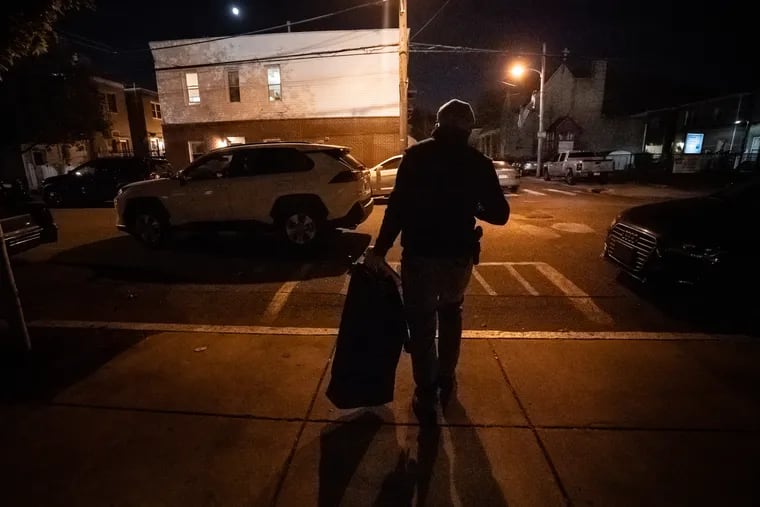 A police officer exits a polling place to bring the hopper, the bag filled with ballots that come out of voting machines as well as provisional ballots, to his vehicle after the polls closed at the Barry Recreation Center in South Philadelphia on Election Day.