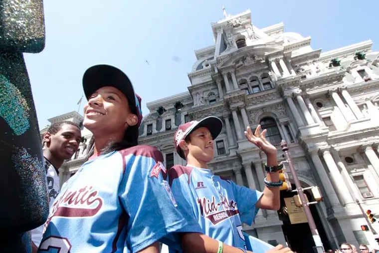 #3 Mo'ne Davis and # 5 Scott Bandura wave to the crowds during the parade for the Taney Dragons in Phila. on Aug. 27, 2014. ( ELIZABETH ROBERTSON / Staff Photographer )