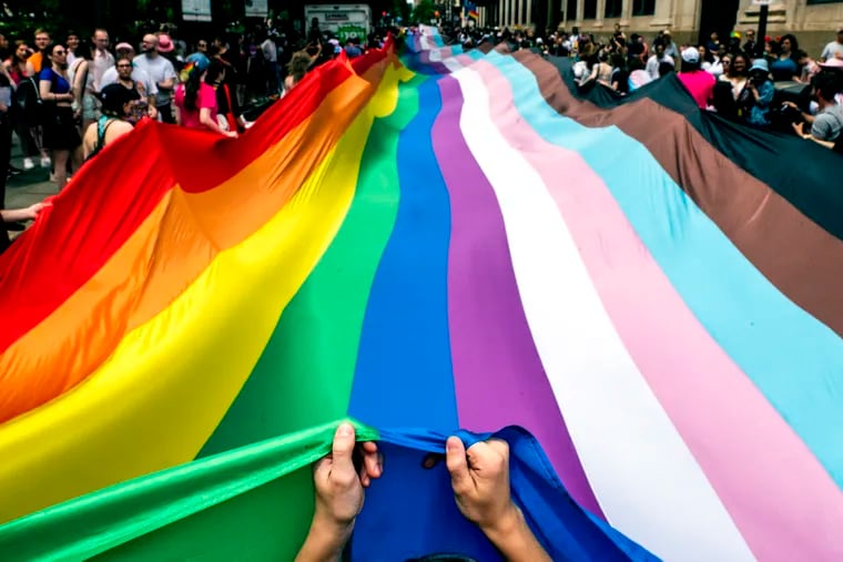 Marchers carry a 400-foot-long rainbow flag - the largest in Philadelphia history - moving it up Walnut Street as Pride March and Festival kicks off with a march from Washington Square on Sunday with the theme, “Be You.”