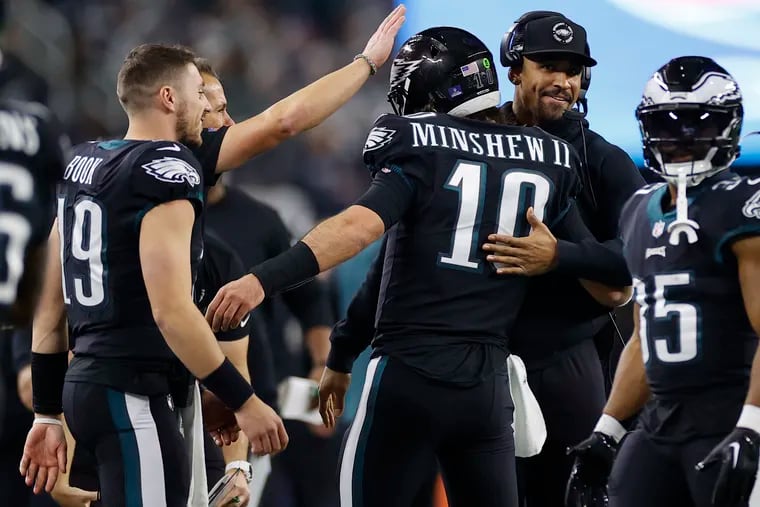 Eagles quarterback Gardner Minshew hugs teammate Jalen Hurts after throwing a third-quarter touchdown during a game the Dallas Cowboys on Saturday at AT&T Stadium in Arlington, Texas.