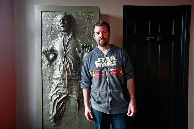 Terrence Laragione, an artist who owns Buzz Cafe, and a sculpture of Han Solo frozen in carbonite.