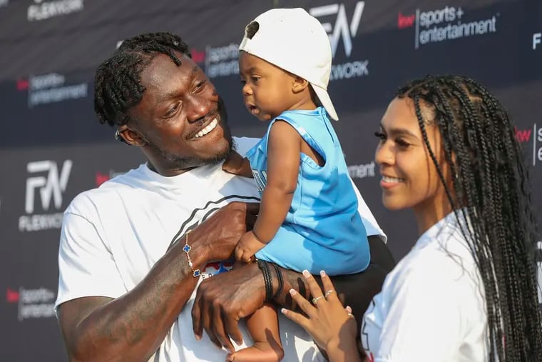 A.J. Brown holds his son, A.J. Jr., while posing for photos with his family during his football camp in Oxford, Miss., on June 9.