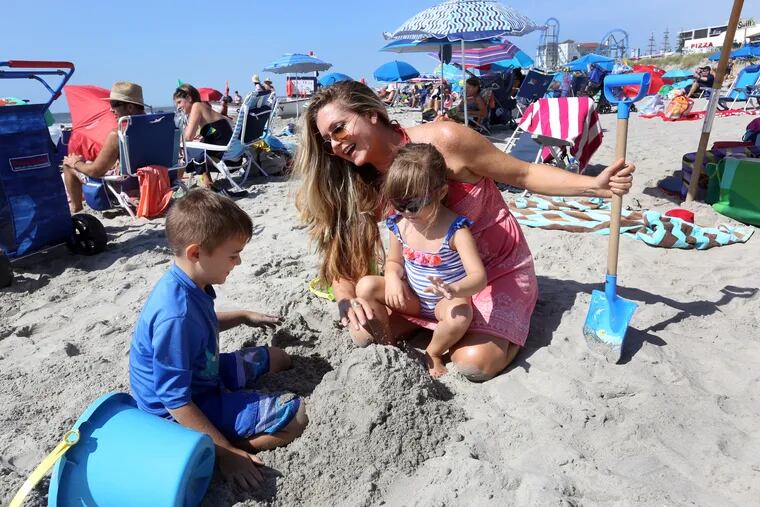 Wendy Kane and her children, Vincent and Ava, of Cherry Hill, play in the sand on the beach in Ocean City Sunday.