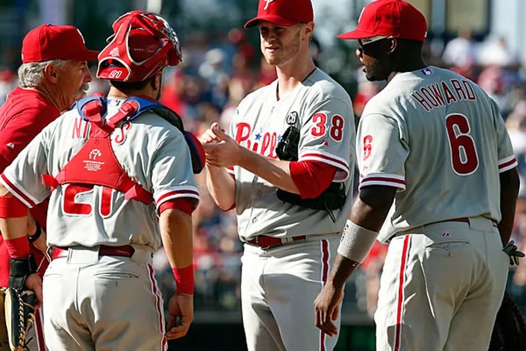 Bob McClure, left, talks to catcher Wil Nieves (21), starting pitcher Kyle Kendrick (38), and first baseman Ryan Howard (6) during the fifth inning of a baseball game against the Washington Nationals at Nationals Park Thursday, June 5, 2014, in Washington. (Alex Brandon/AP)