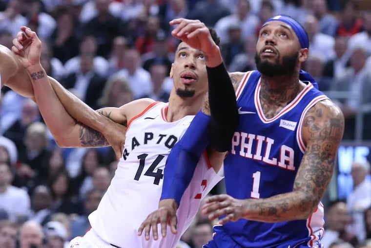 DAnny Green, left, of the Raptors and Mike Scott of the Sixers battle for rebounding position during their NBA Eastern Conference semifinal game at the Scotiabank Arena in Toronto on May 7, 2019.