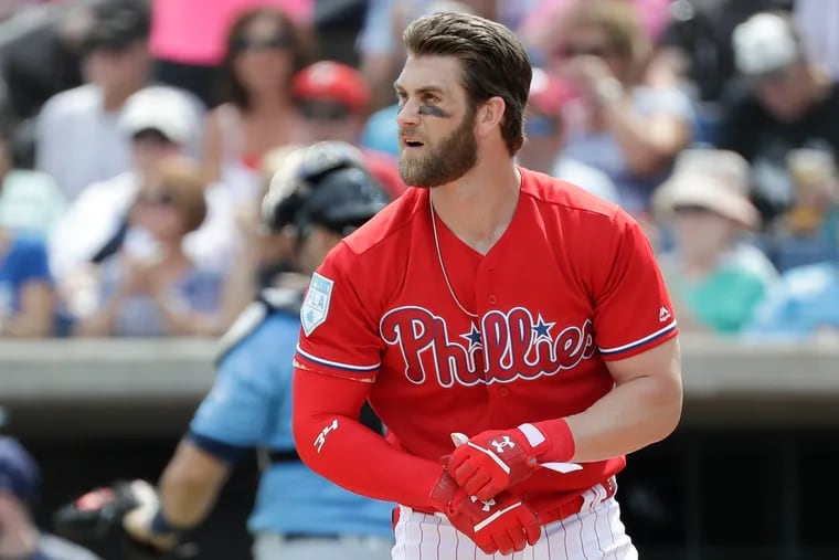 Bryce Harper walks off the field after striking out during his first at-bat on Monday.