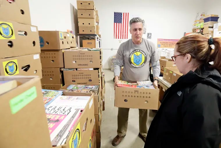 Larry Abrams helps Emily Thomas, a teacher at Farrell Elementary in Philadelphia, find appropriate books for her students at BookSmiles in Cherry Hill.
