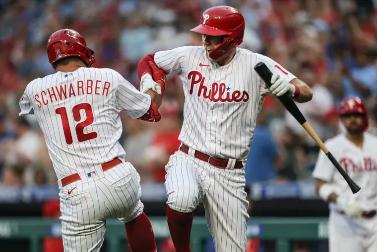 Kyle Schwarber celebrates with teammate Rhys Hoskins after his second home run of the game against the Nationals in the third inning Tuesday. The Phillies won, 11-0.