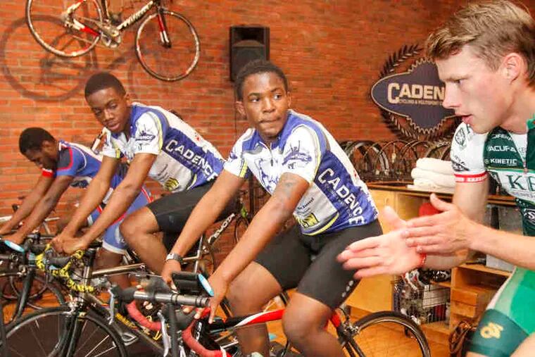 Professional cyclist Tom Soladay (right) gives tips to Festus Aigbokhai while they train on stationary bikes. With them are (from left) Sam Cowans and Eric Goodwin.