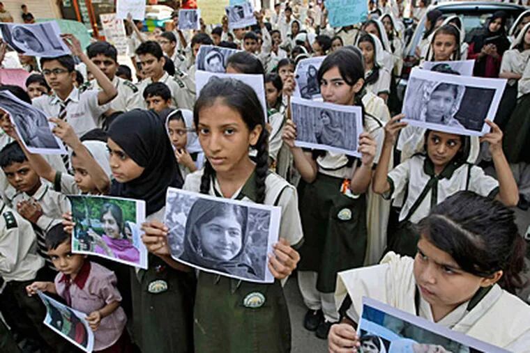 Pakistani students show support for wounded 14-year-old schoolgirl Malala Yousafzai by holding up her picture. She was shot Tuesday for advocating education for girls. (AP)