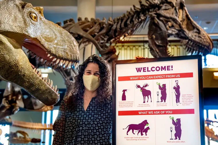Designer Stephanie Gleit poses at the Academy of Natural Sciences of Drexel University Jan. 12, 2021 with the COVID signage she designed. She is one of the designers who create interesting COVID social distancing signage for their public spaces.