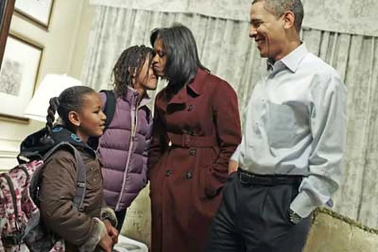 Then President-elect Barack Obama and his wife Michelle Obama prepare their daughters Sasha, 7, and Malia, 10, for their first day of school in Washington in early January. Obama, a family man, can be a good role model for young men across the country. (AP File Photo/Obama Transition Office, Callie Shell)