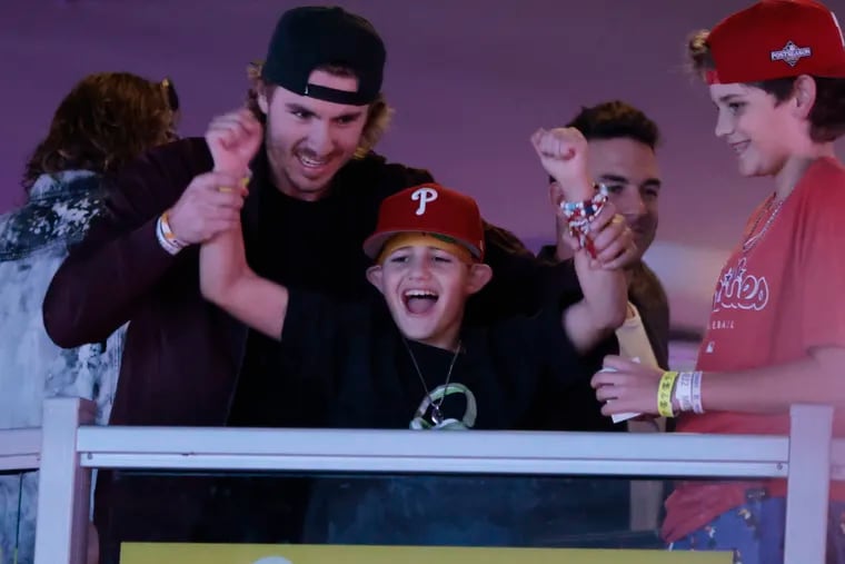 Phillie Bryson Stott (left) sings along with Liam Castellanos — the son of Phillies right fielder Nick Castellanos — at Xfinity Live! after Game 4 of the NLDS game against the Atlanta Braves. Liam is selling a hand-illustrated Phillies T-shirt, with proceeds going to the Kisses for Kyle Foundation.