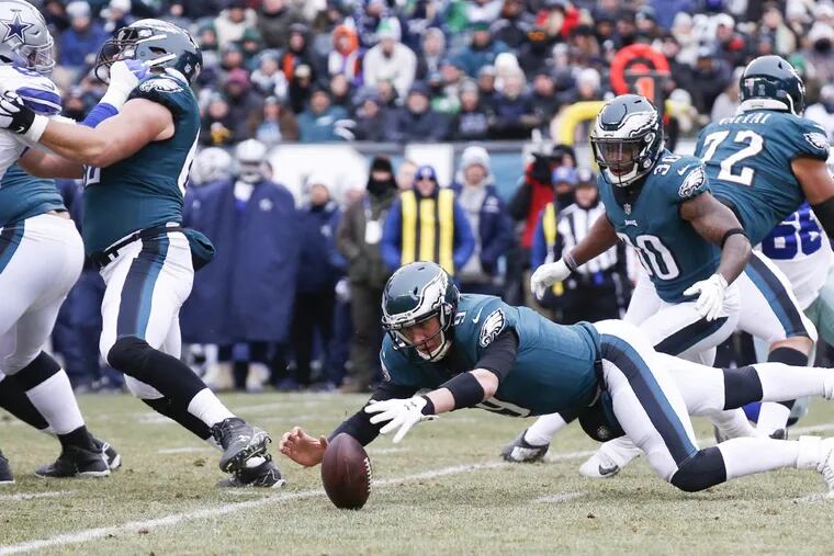 Eagles quarterback Nick Foles dives for the football after fumbling a snap against the Dallas Cowboys.