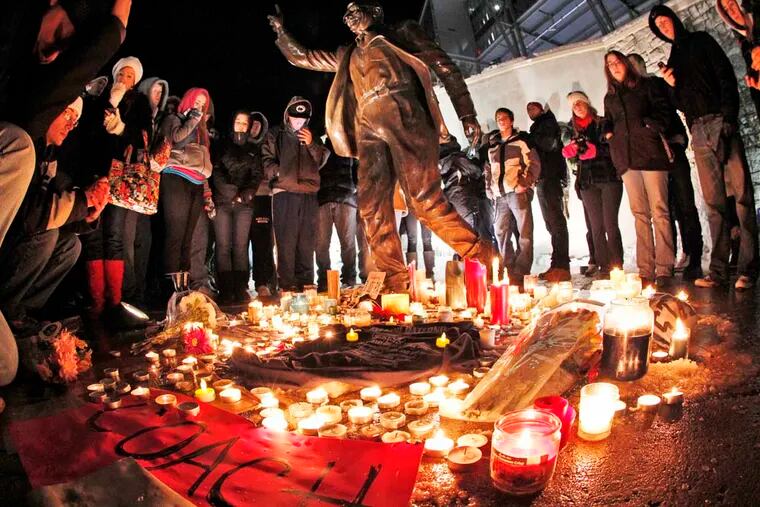 Candles and memorabilia are placed by well wishers at the foot of a statue of Joe Paterno outside Beaver Stadium on the Penn State University campus Saturday, Jan. 21, 2012.  (AP Photo/Gene J. Puskar)