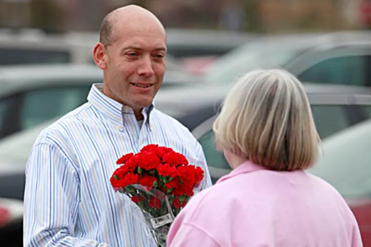 David Friedman offers surprise flowers to nurse Nancy Haas, a stranger, at the Mount Laurel Wegmans. He blogs about his daily pursuit. (David Swanson / Staff Photographer)