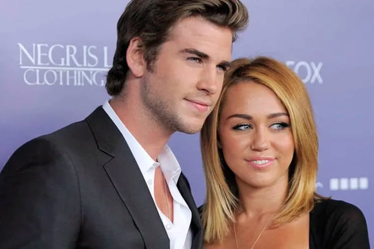 Actor Liam Hemsworth, left, an honoree at the Australians in Film 8th Annual Breakthrough Awards, poses with his fiance Miley Cyrus on Wednesday June 27, 2012, in Los Angeles. (Photo by Chris Pizzello/Invision/AP)