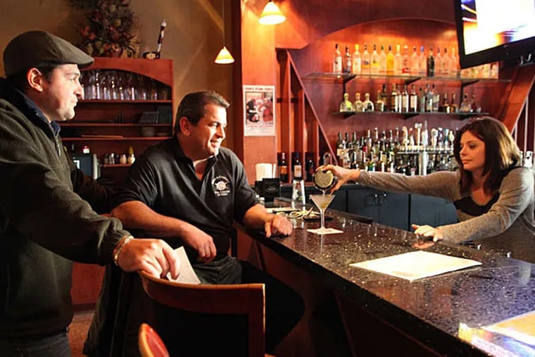 Above, Shannon Atturo serves a drink to regular customer Steven Pasquini, joined by restaurant co-owner Joe Abbate at the bar of Villari's Lakeside. (KELSEY ANNE DUBINSKY / Staff Photographer)