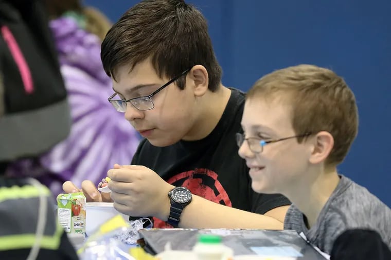 Ben Cotton, 12 (left), eats his breakfast in the cafeteria. Studies show that children who eat breakfast in school do better academically and make fewer visits to the school nurse than those who skip breakfast.