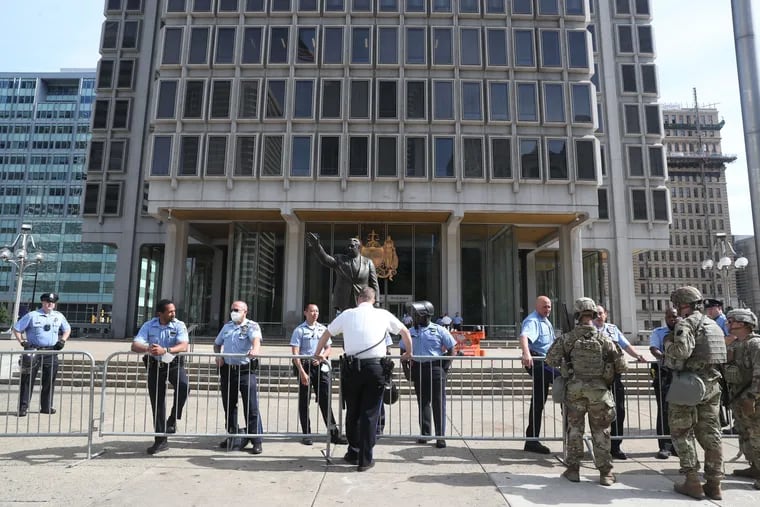 Philadelphia Police officers and Pennsylvania National Guard members stand at the Municipal Services Building in Philadelphia on Monday, June 1, 2020.