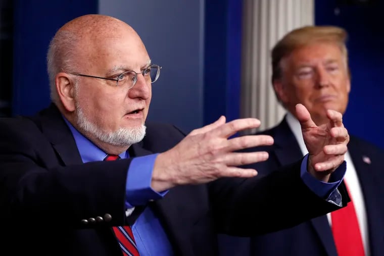 President Donald Trump listens as Dr. Robert Redfield (left), director of the Centers for Disease Control and Prevention, speaks at the White House Wednesday.