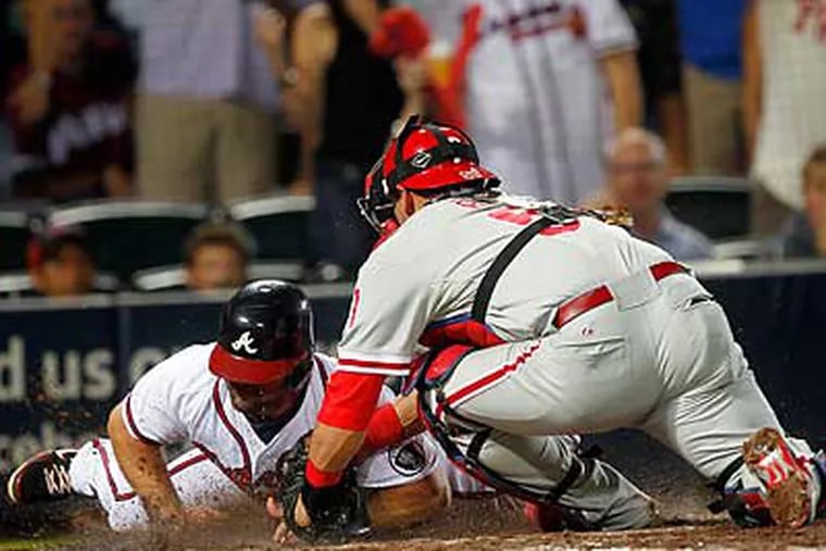 Carlos Ruiz tags out Dan Uggla at home on a throw by Hunter Pence in the sixth inning. (John Bazemore/AP)