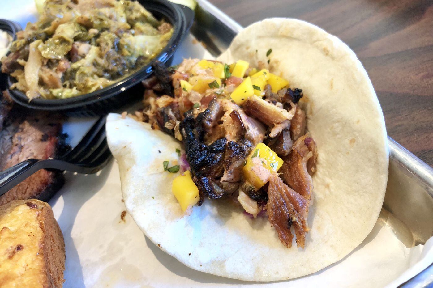 The smoked pork belly taco at Smoke BBQ in Audubon layers slow-cooked morsels of pork with a mango salsa that's also been smoked.