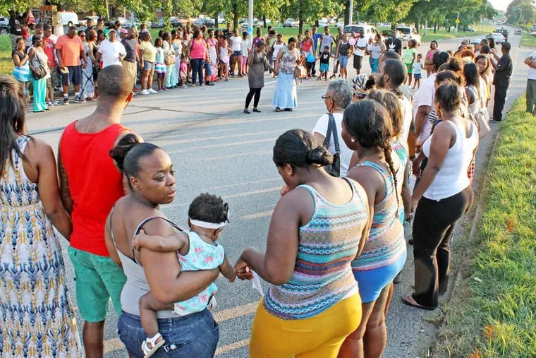 A crowd gathers at the location on the Boulevard where Samara Banks and three of her children were killed hours after a crash in July 2013.