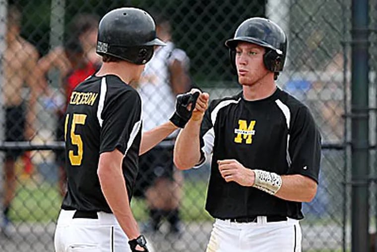 Moorestown's Andrew Lisa (right) is congratulated after scoring a run by Drew Peterson. (David M Warren/Staff Photographer)