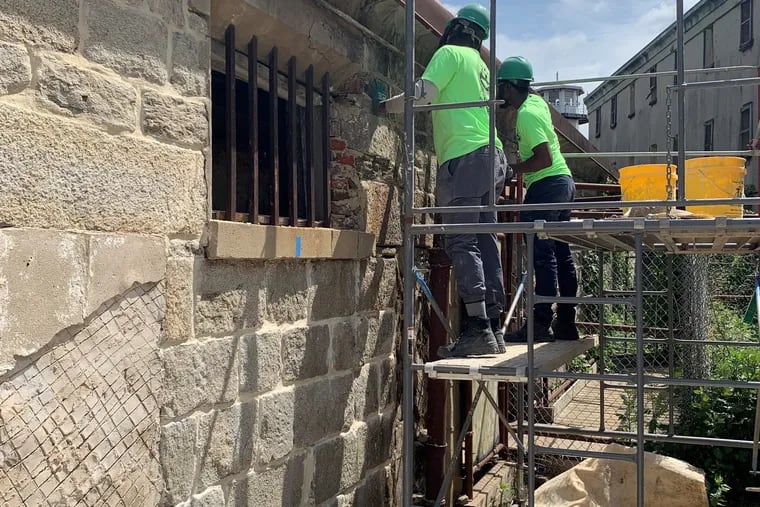Previous Rebuild academy participants restore the walls of the Eastern State Penitentiary.