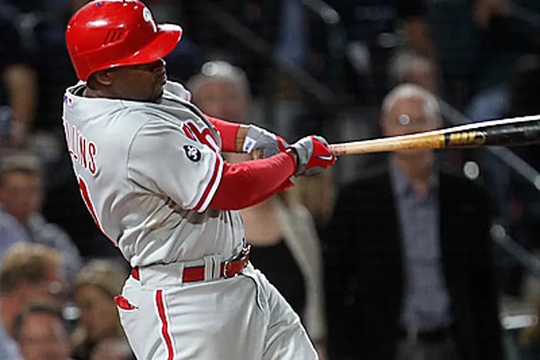 Jimmy Rollins follows through with a grand slam in the sixth inning of the Phillies 11-5 win over the Braves.  (AP Photo/John Bazemore)