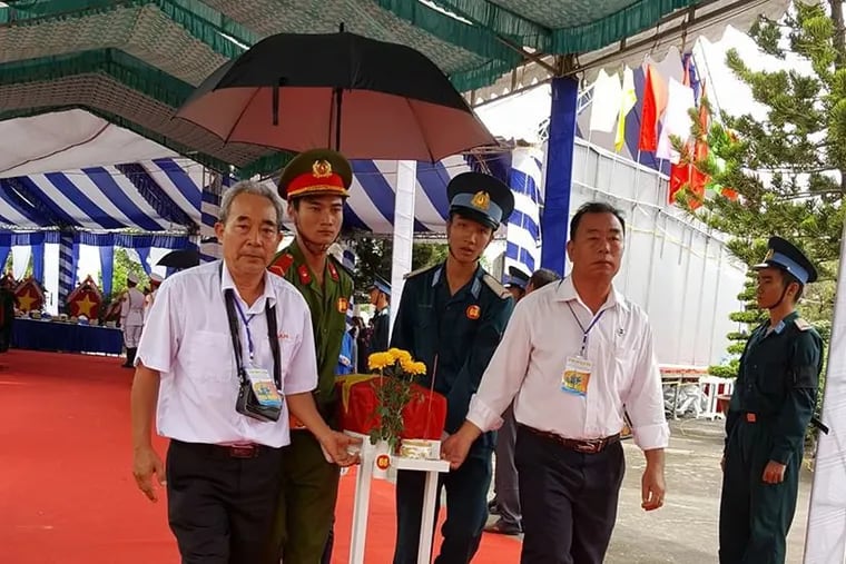 North Vietnamese People’s Army veteran Che Trung Hieu (left) helps carry the remains of a soldier found in a mass grave at Bien Hoa Air Base in Vietnam. The remains were found with the help of two U.S. veterans stationed at the base in 1968. The reburial  ceremony for the soldiers was in July.