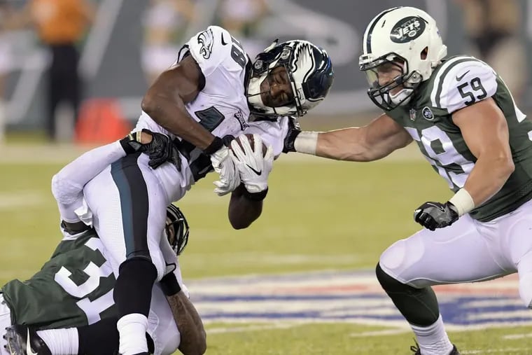 Eagles wide receiver Shelton Gibson, center, is hit by Jets cornerback Derrick Jones.