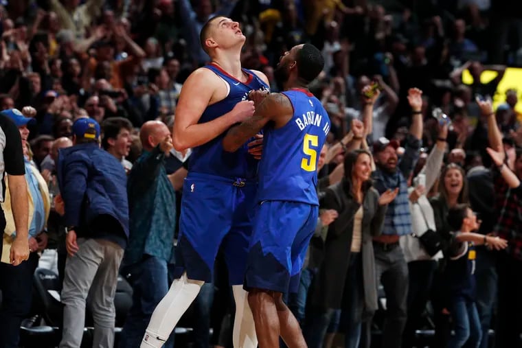 Denver Nuggets center Nikola Jokic, left, is congratulated by guard Will Barton III after hitting the winning basket in the second half of an NBA basketball game against the Philadelphia 76ers, Friday, Nov. 8, 2019, in Denver.