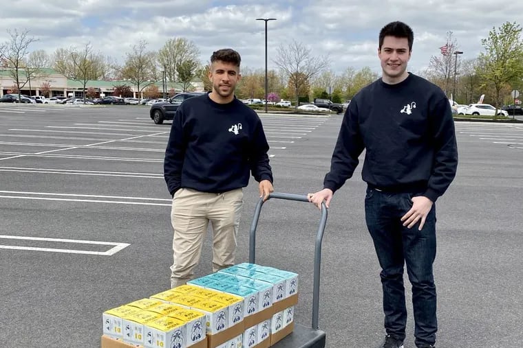 Osena founders Chris Allen (left) and Vicente Surraco unload cases of the spiked coconut water at a distributor's dock.