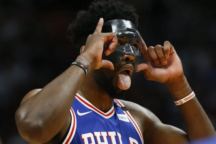 Sixers center Joel Embiid adjust his mask before shooting free throws against the Heat during the third quarter of the Sixers’ Game 3 win.