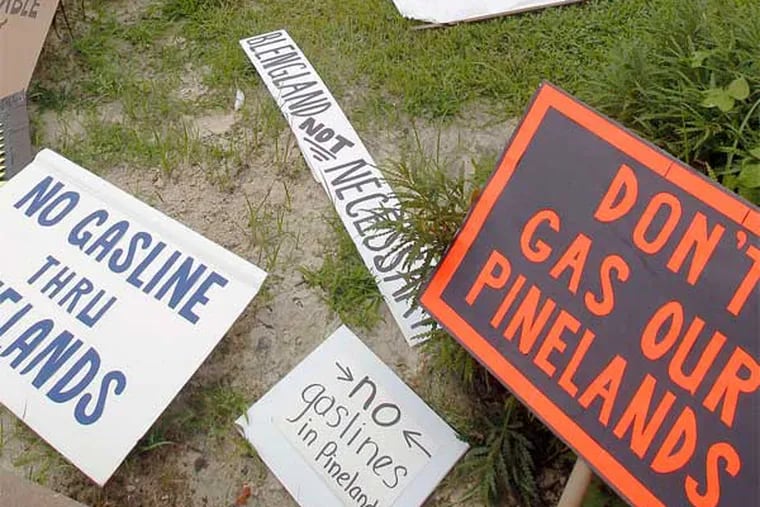 Protest signs from a 2018 hearing on South Jersey Gas pipeline proposal. The company announced Thursday it was being sold for $8.1 billion to a private investment fund.
