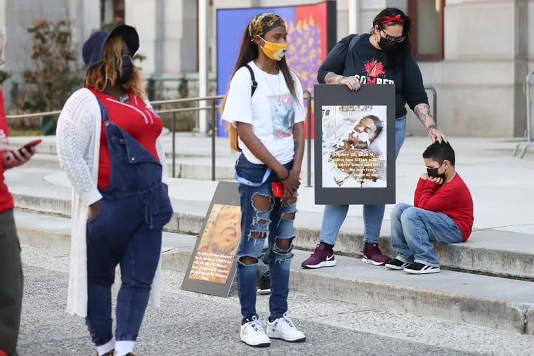 Carmen Pagan, of North Philly, comforts her son, Jace Neal, 6, while holding a photo of her other son, Elijah, who was shot and survived but still has three bullets lodged in his body during a rally to stop gun violence outside of City Hall in Philadelphia on Friday, March 26, 2021.