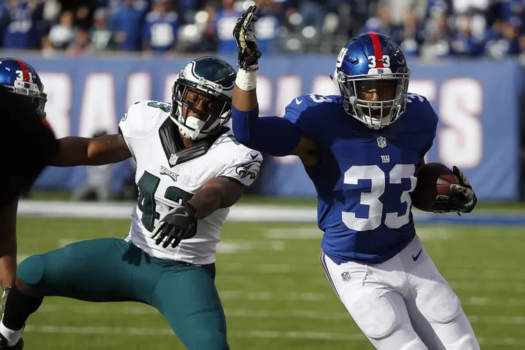 The Eagles’ Darren Sproles, left, pushes the Giants’ Andrew Adams out of bounds after he intercepts a pass during the team’s game last November.