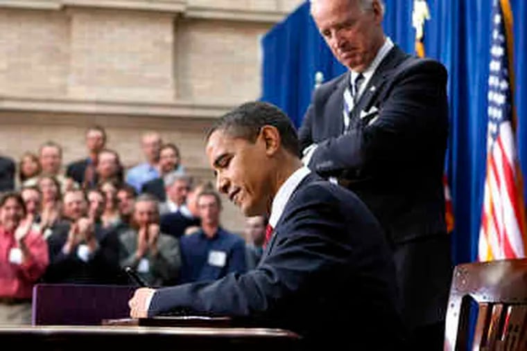 President Obama signs the $787 billion stimulus plan in Denver as Vice President Biden watches. Obama said the plan marked &quot;the beginning of what we need to do to create jobs for Americans.&quot;